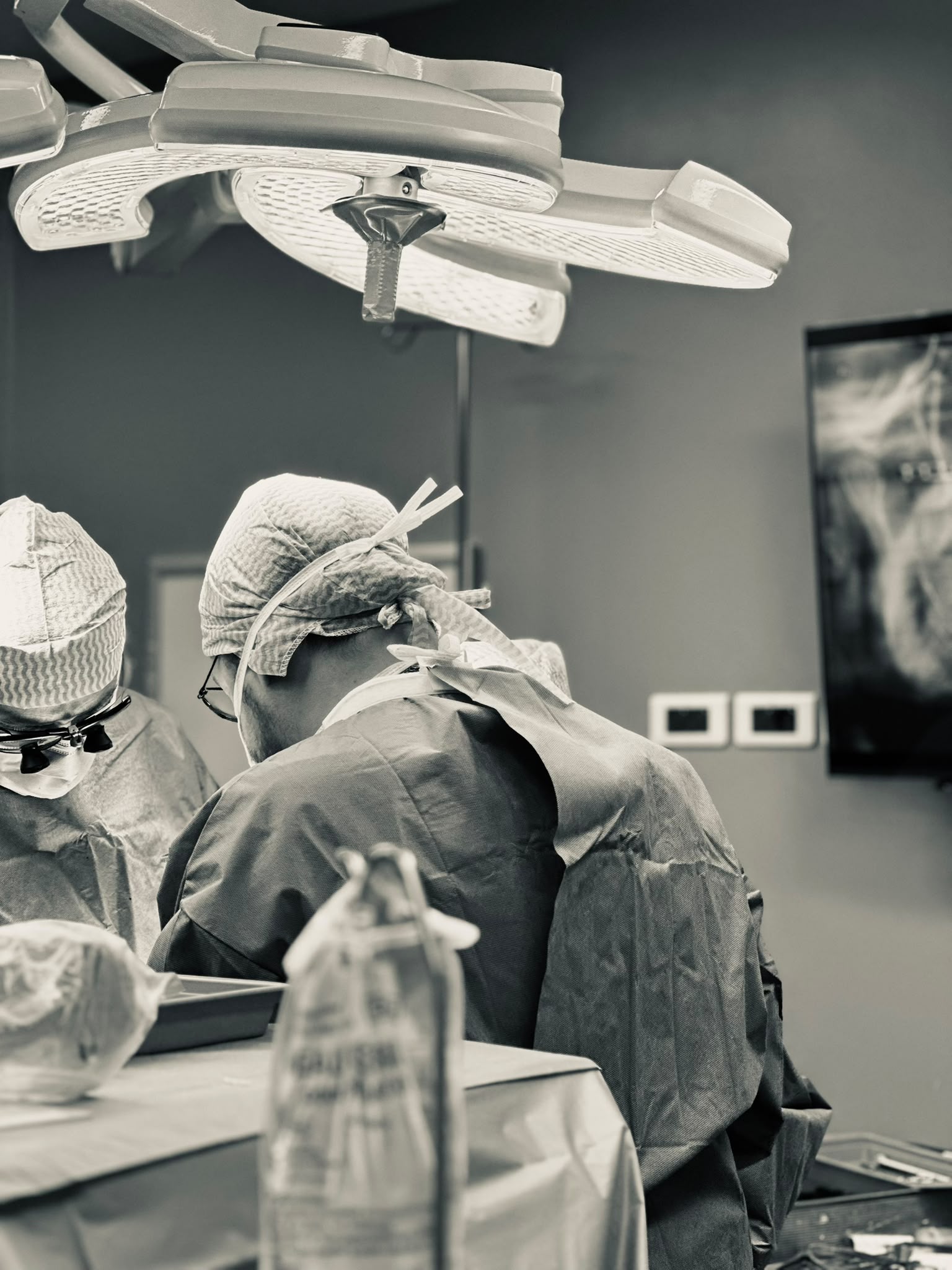 Équipe d'anesthésistes-réanimateurs et de chirurgiens au travail sous les scialytiques du bloc opératoire
